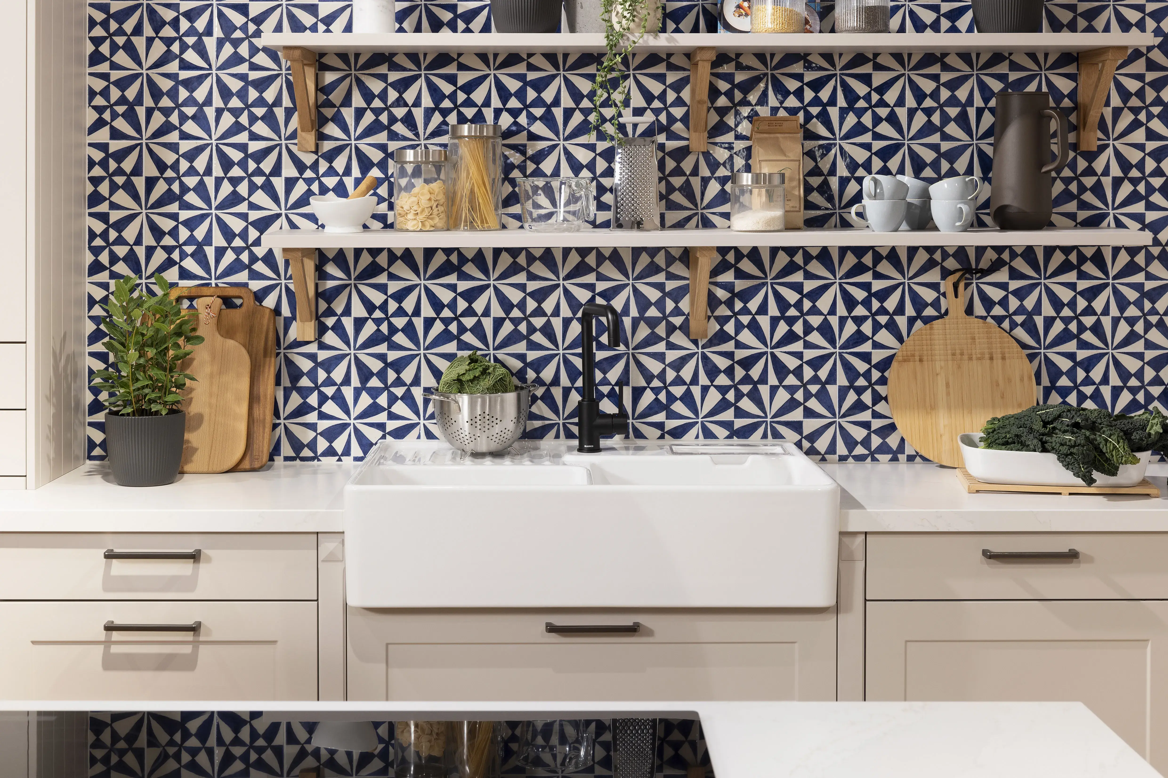 Moderne Küche mit weißem Spülbecken, gemusterter blauer Wand und offenen Regalen